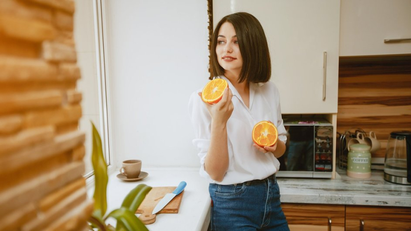 Девушка разрезала апельсин, чтобы его запах привлек в дом гармонию и богатство
