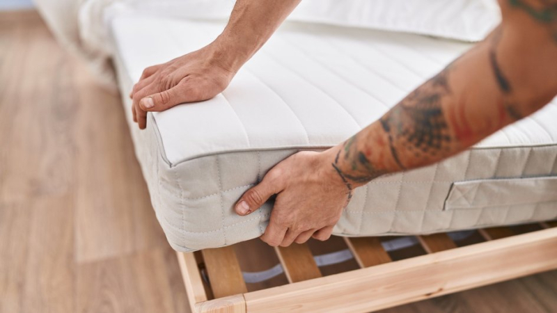 Мужчина тестирует качество матраса, чтобы тот не навредил позвоночнику