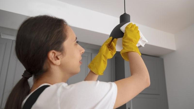 Девушка моет люстру без снятия прибора с потолка