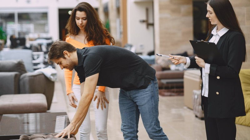 Пара в магазине выбирает предметы интерьера, на которых не стоит экономить