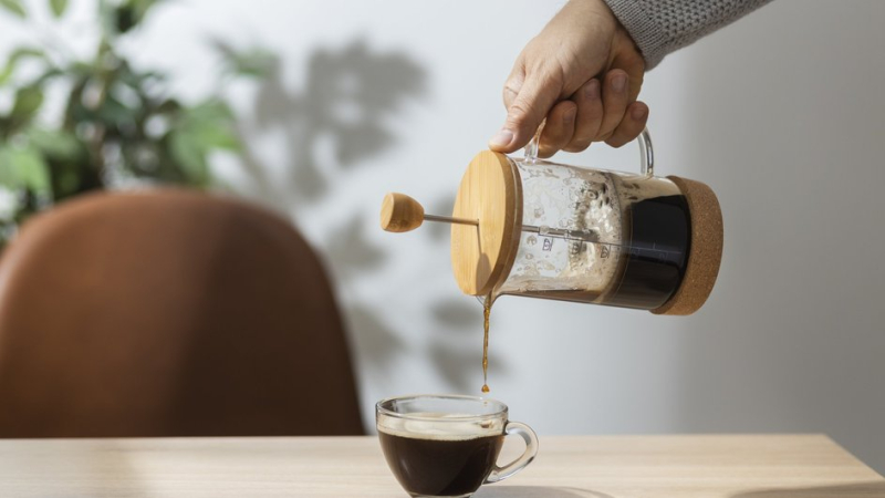 Мужчина наливает кофе из френч-пресса 