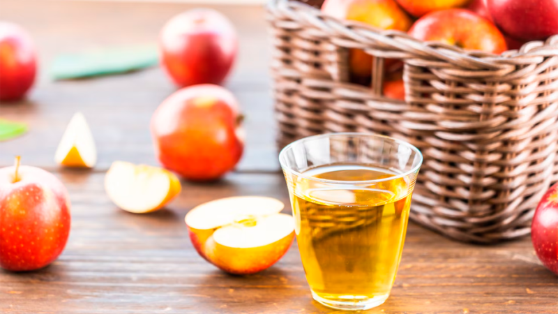 Выжитый прессом яблочный сок в стакане 